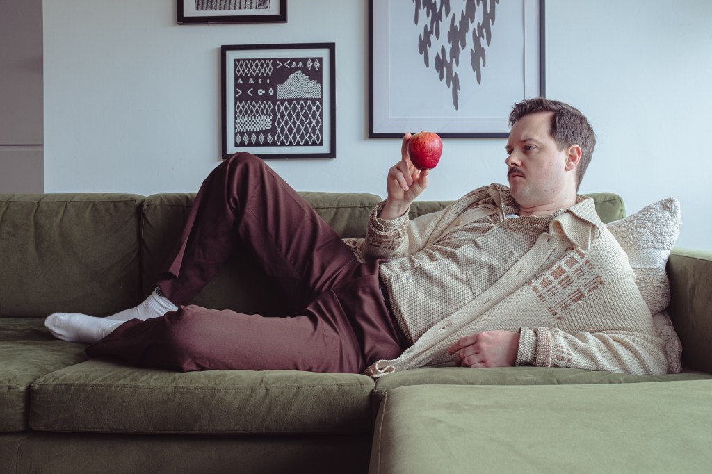 Andy Barr reclines at home, contemplates apple. Image credit - Michael Julings
