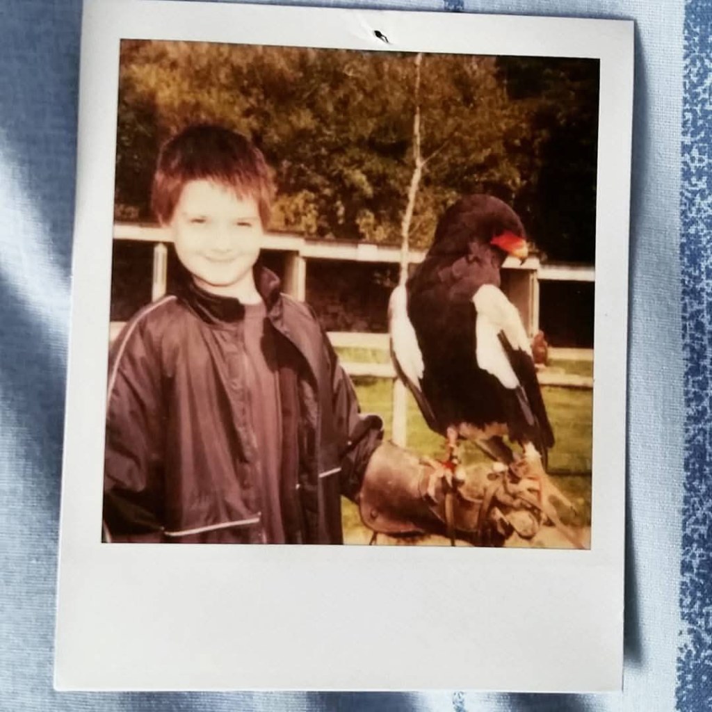 A very small Barr poses with a large (relative) Bateleur Eagle, with a distinctive red and yellow beak